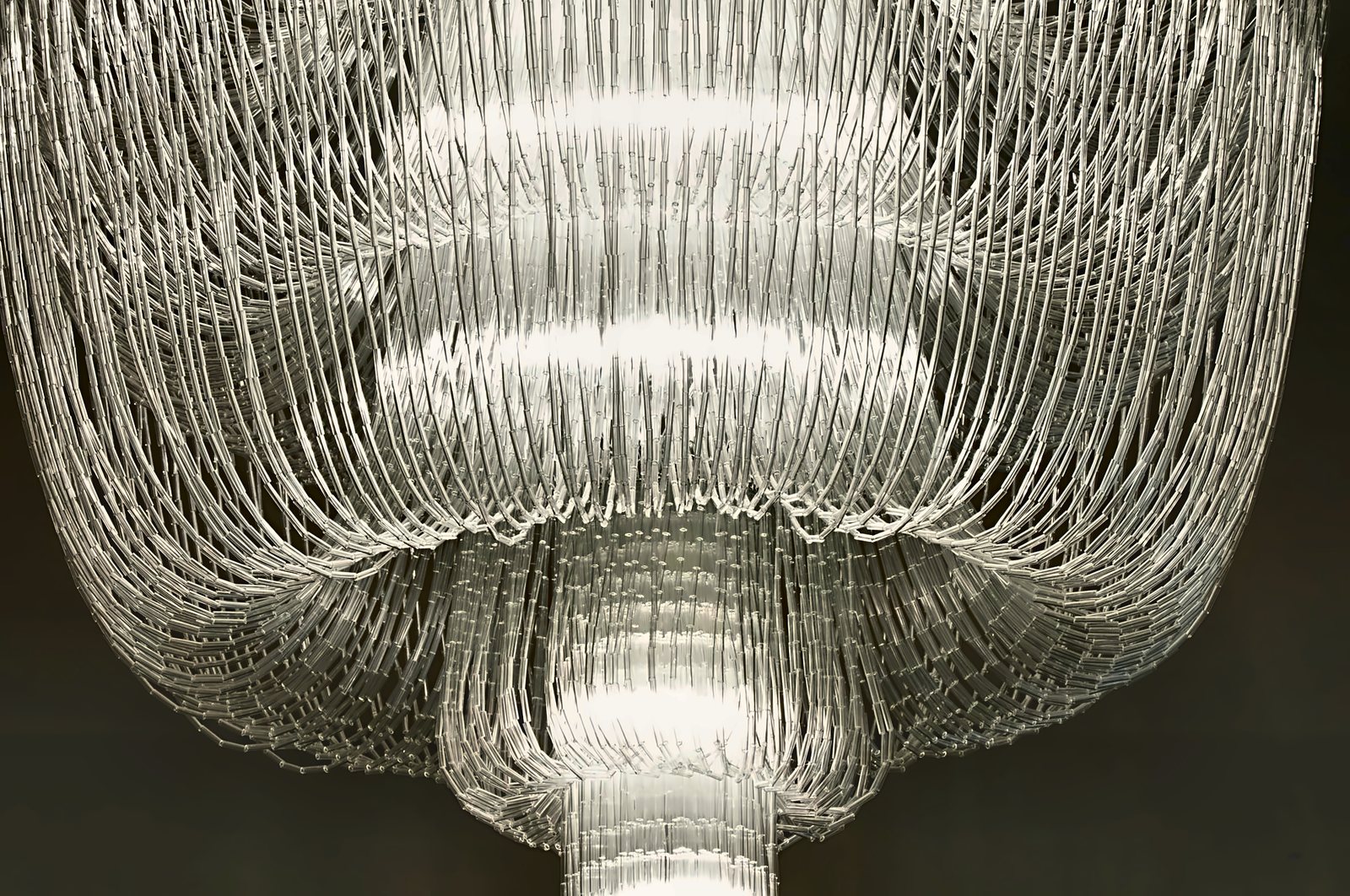Il lampadario a piani di cannette di vetro della sala da pranzo di Villa Le Maschere, acceso