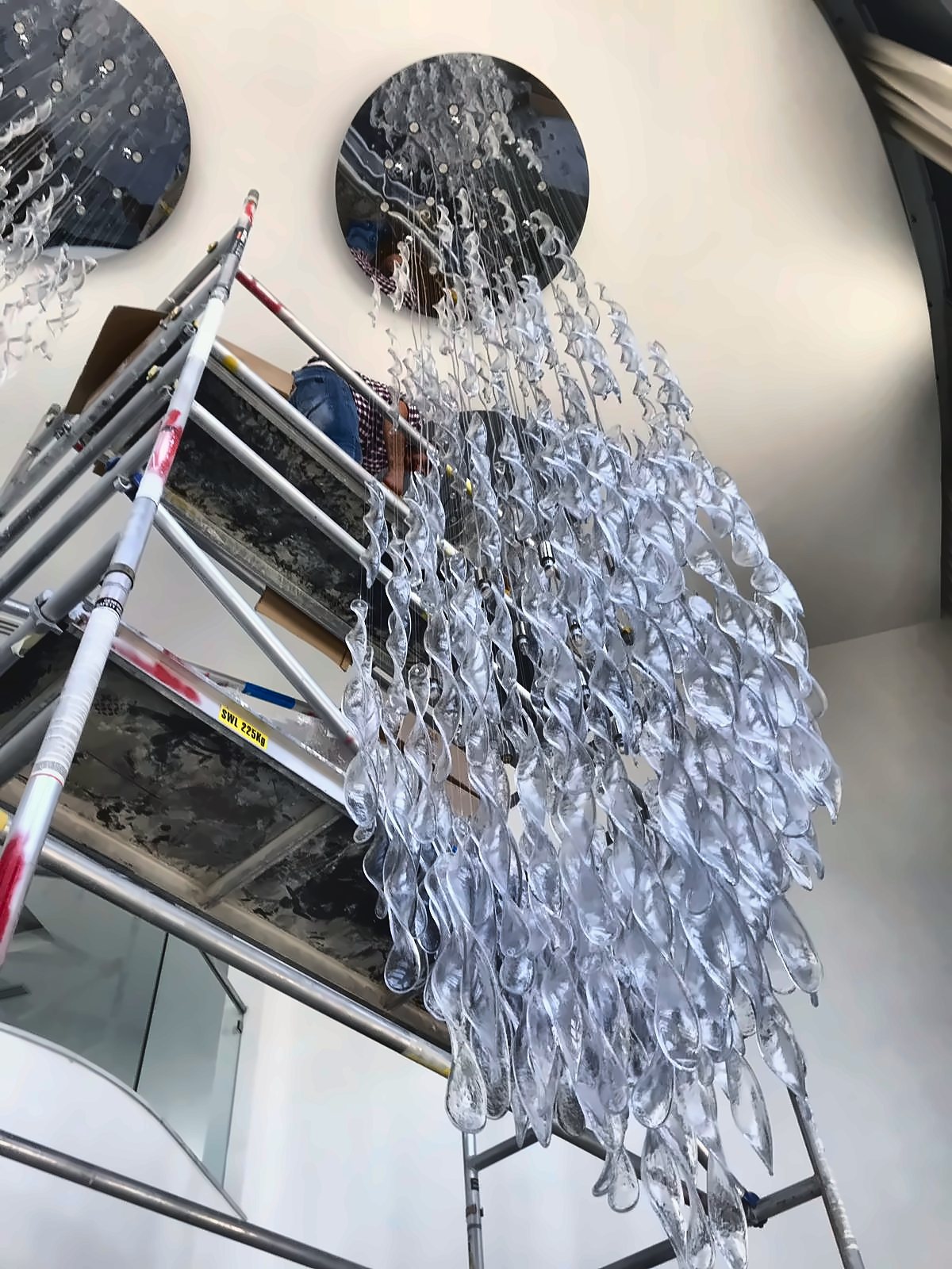 La cascata in montaggio sul ponteggio, con i nastri di vetro agganciati uno alla volta