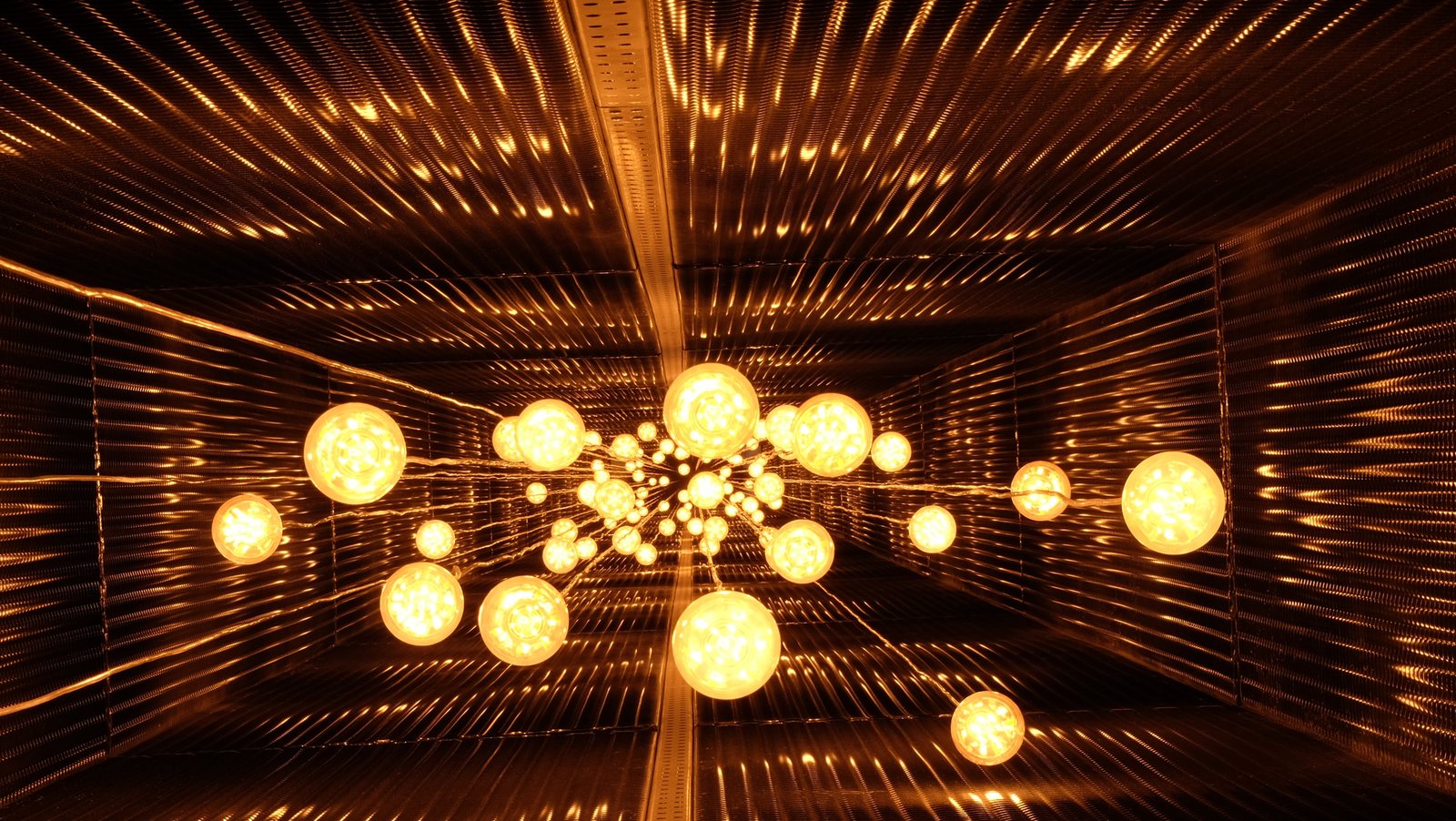 La sala foderata di doghe arancio con il grappolo di globi luminosi al centro