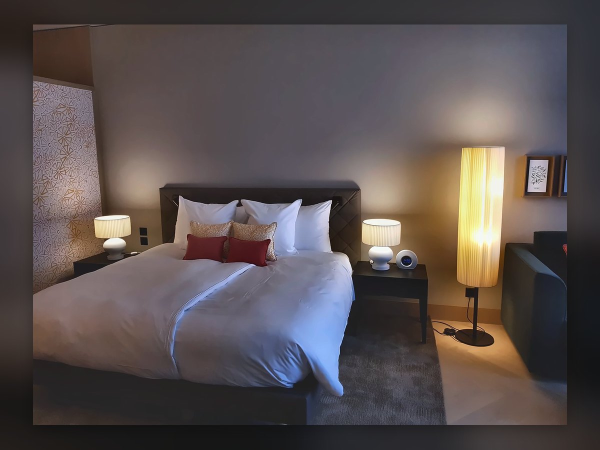 Camera del Waldhotel con colonna luminosa da terra e lampade da comodino
