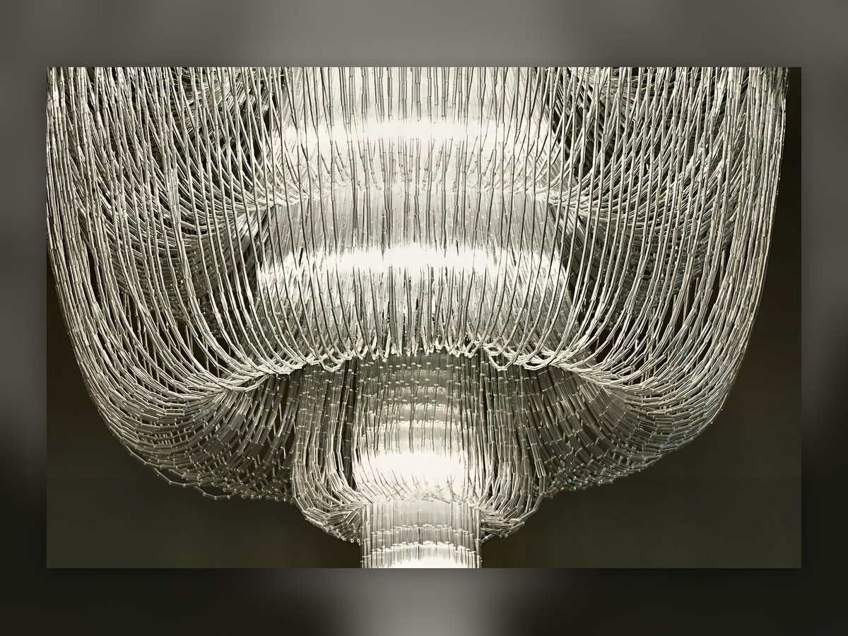 Il lampadario a piani di cannette di vetro della sala da pranzo di Villa Le Maschere, acceso