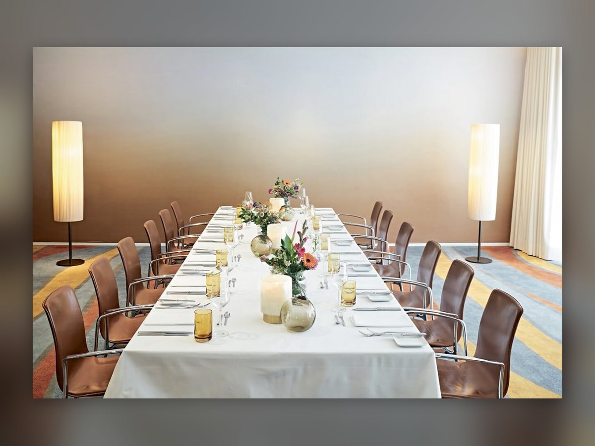 Due piantane cilindriche con paralume plissettato ai lati della tavolata nella sala privata del SIDE Hotel