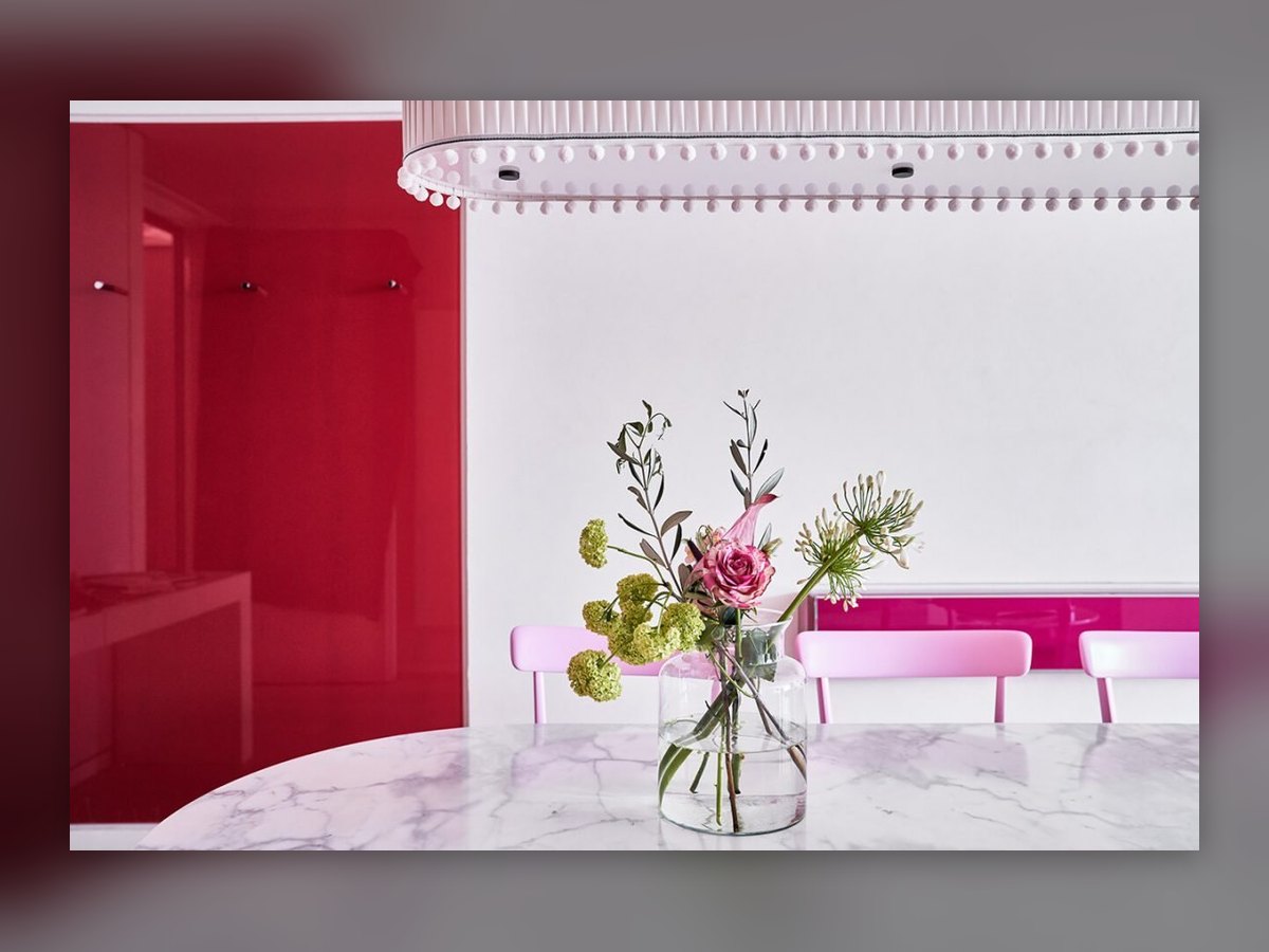 La fila di piccole sospensioni cilindriche lungo il soffitto della sala rosa, sopra il tavolo in marmo