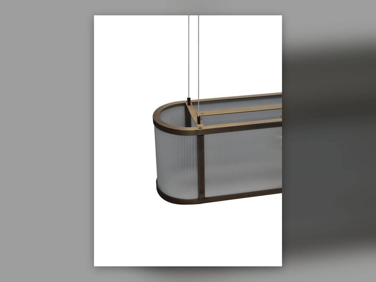 La tête courbe du luminaire ovale, vue de trois quarts, avec le verre cannelé qui suit le pli