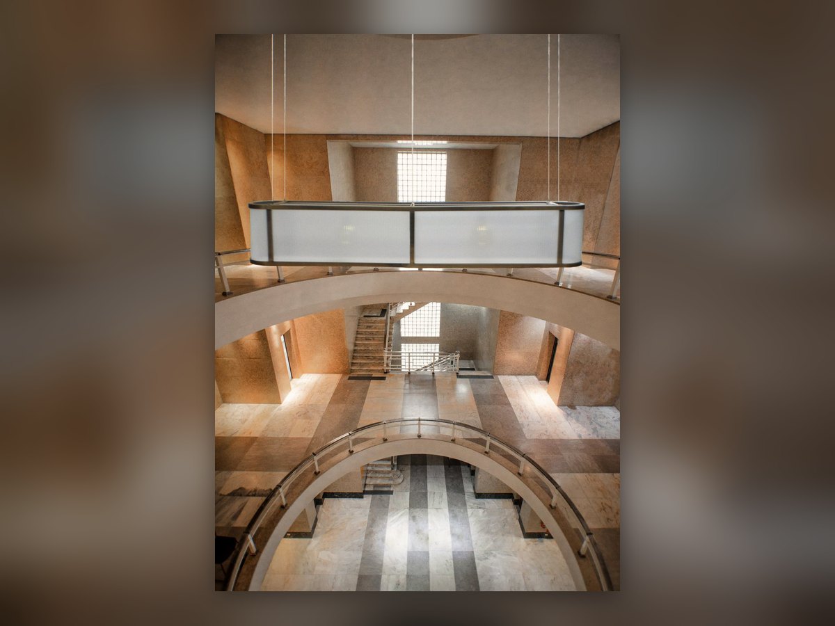 Restitution d'ambiance du luminaire ovale suspendu dans une salle en double hauteur en pierre
