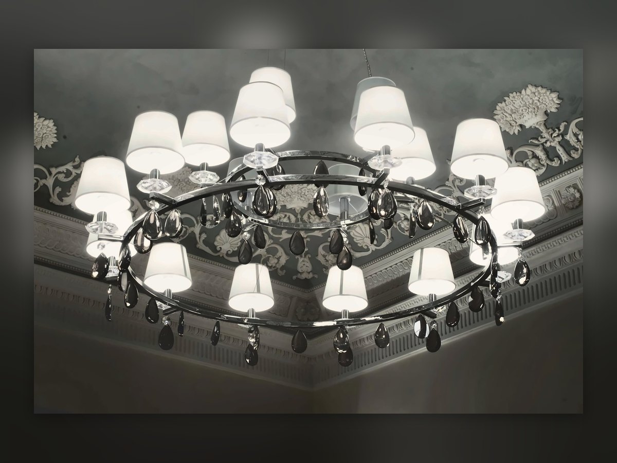 Lampadario ad anello con paralumi in tessuto e gocce di cristallo, sotto il soffitto decorato