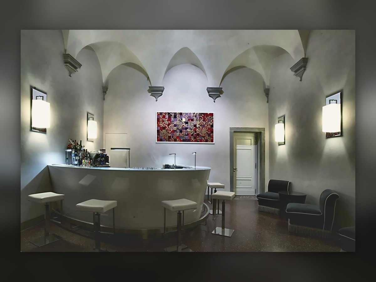 Il bar di Villa Le Maschere sotto le volte, con le applique quadrate sulle pareti