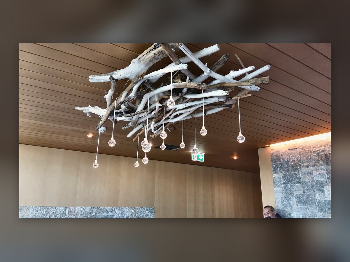 La grappe de gouttes vue d'en bas : les branches blanches et les gouttes de verre suspendues à des hauteurs différentes