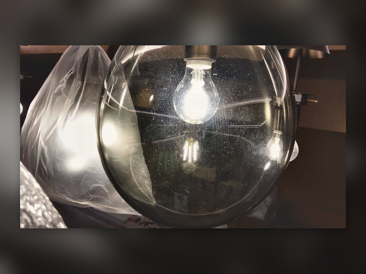 Sphère en verre transparent avec ampoule à filament, encore protégée par la bâche de chantier
