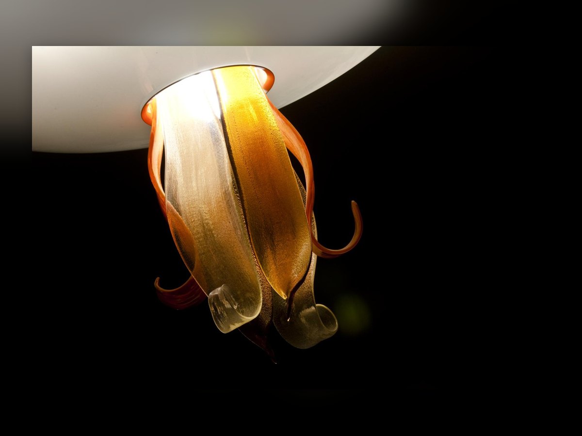 Il fiore in vetro ambra sotto la coppa, coi petali che si arricciano verso l'alto