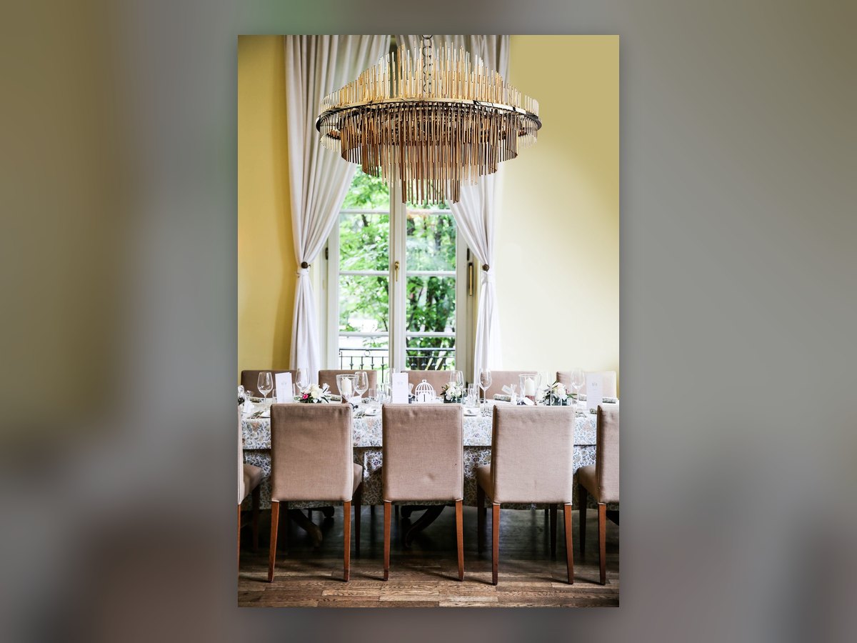 Il lampadario GF200 acceso sopra la tavola apparecchiata, davanti alla finestra sul giardino