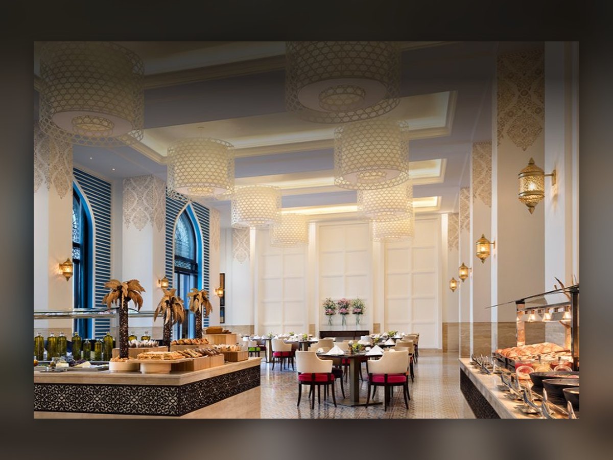 La sala delle colazioni, con le lanterne appese sotto gli archi e il buffet in primo piano