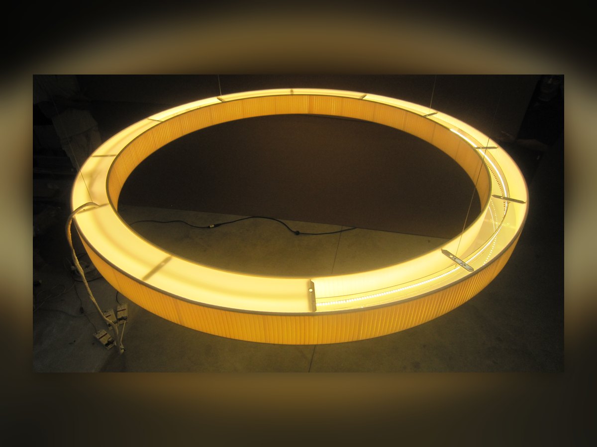 Der große Ring aus plissiertem Stoff eingeschaltet, von unten in der dunklen Werkstatt gesehen