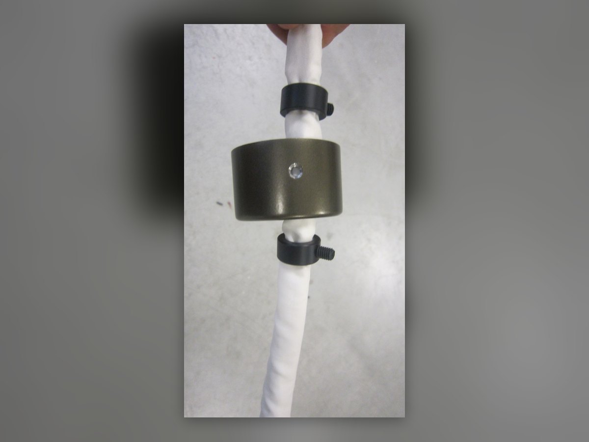 Die Bronzerosette auf dem stoffummantelten Abhängekabel