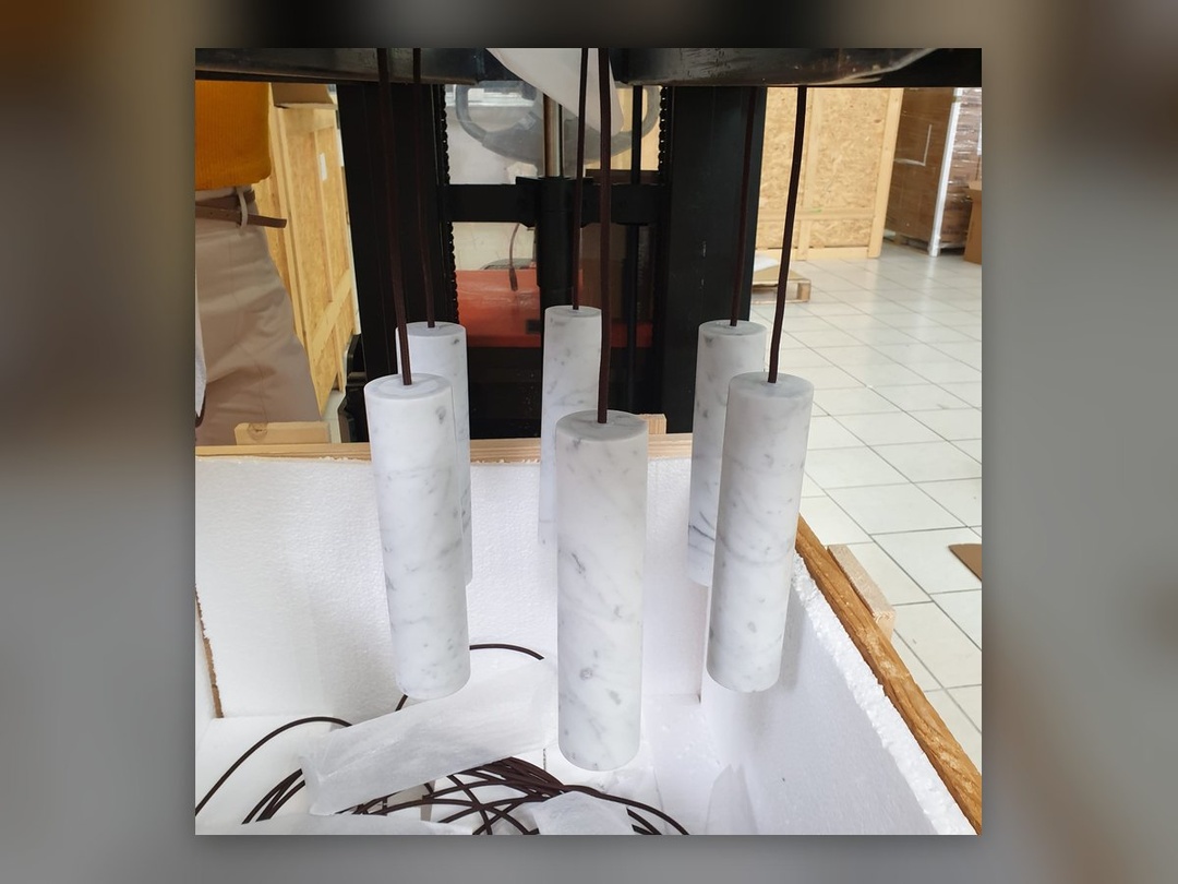 Marmorzylinder unterschiedlicher Höhe über der Styroporverpackung