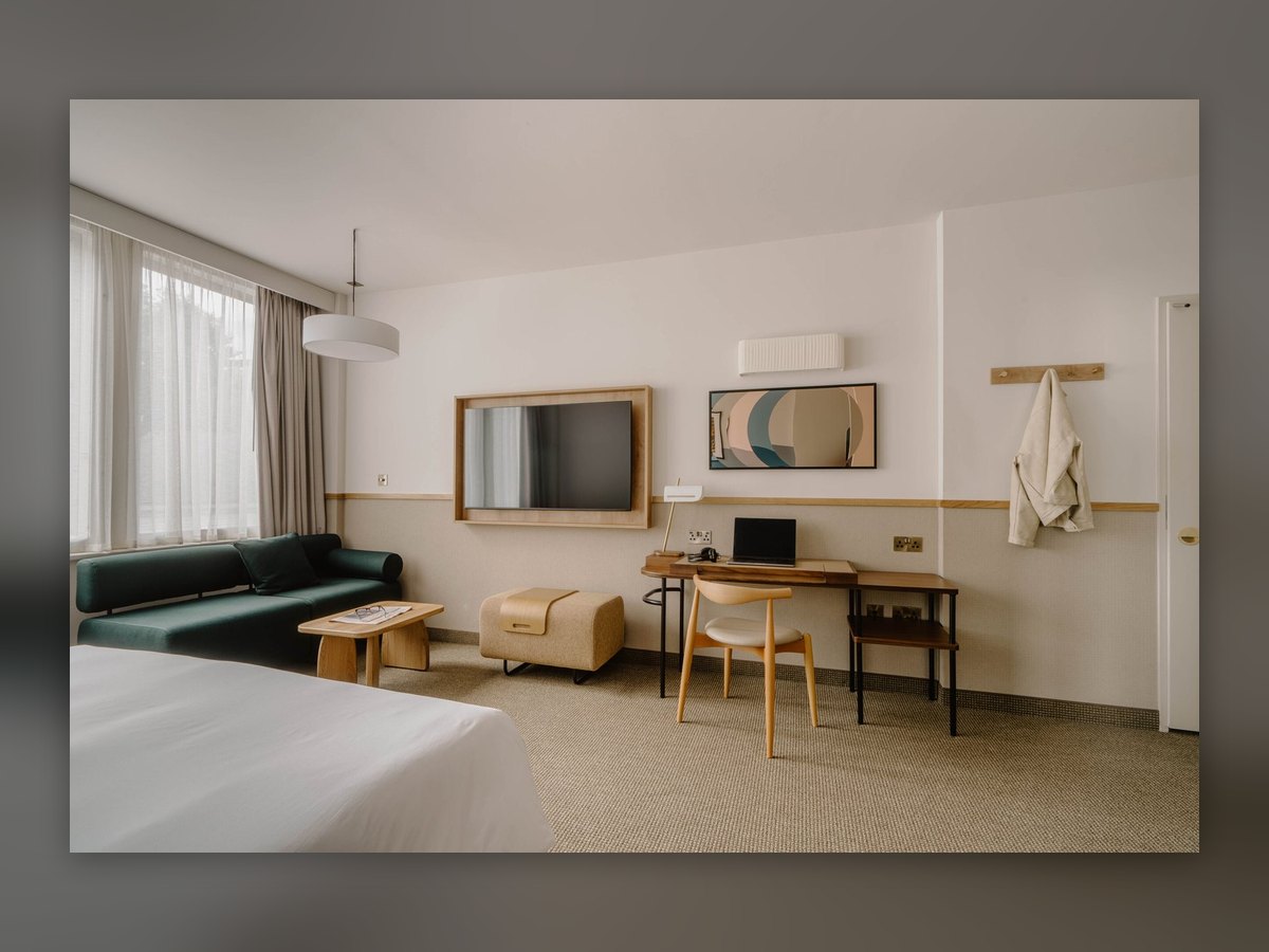 Superior-Zimmer im Club Quarters St Paul's, London: Wandleuchte E12 aus elfenbeinfarbenem Plisseestoff über Fernseher und Schreibtisch